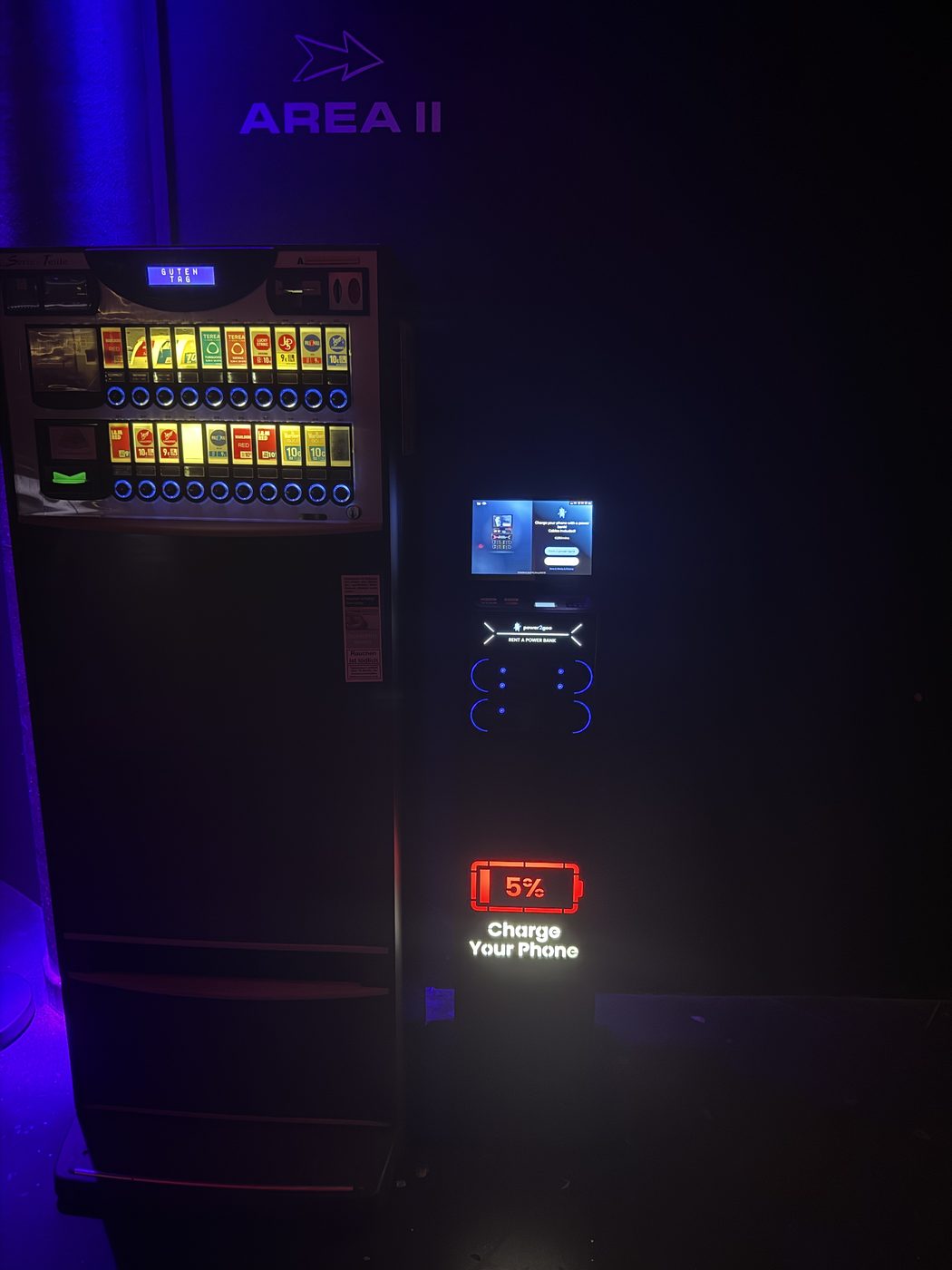 power2goo Powerbank-Station mit leuchtendem „Charge Your Phone“-Schild neben dem Zigarettenautomaten in einem Club in Nürnberg